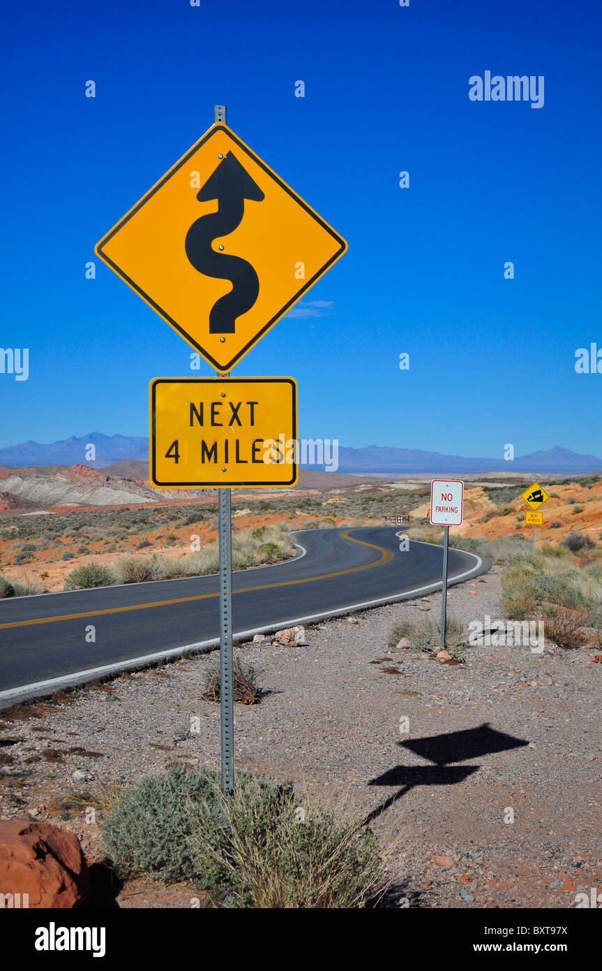 Sign warning of sharp bends along a desert road in Nevada Stock Photo