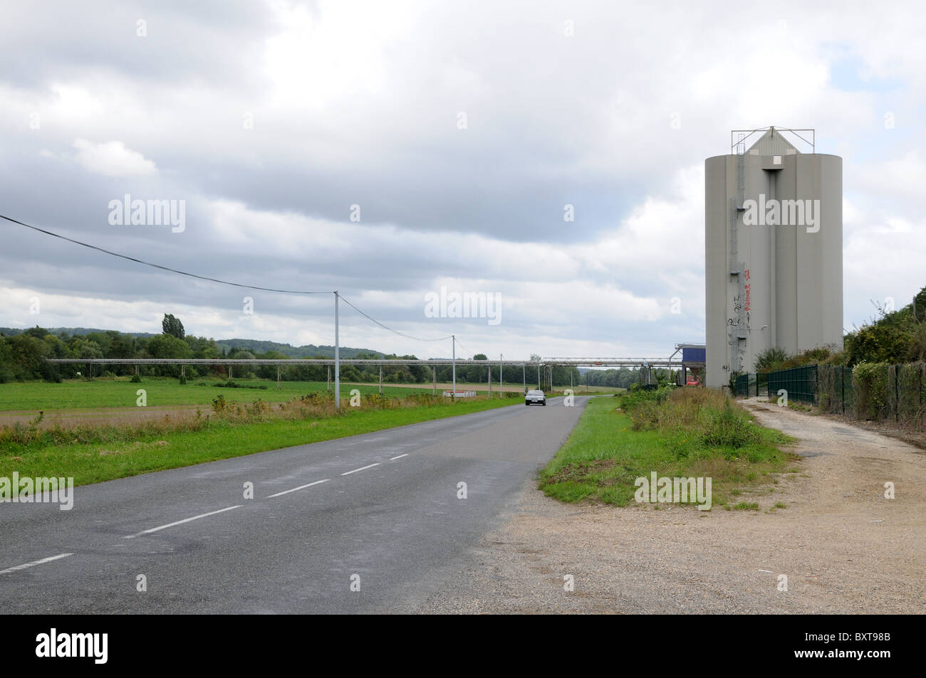 A grain silo on the D3 depatment road just west of La Ferte sous Jouarre A wcovered overhead conveyor belt links to river Marne Stock Photo