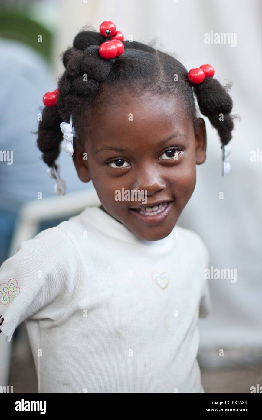 A Haitian child living a temporary camp waiting for food assistance from a humanitarian aid agency. Stock Photo