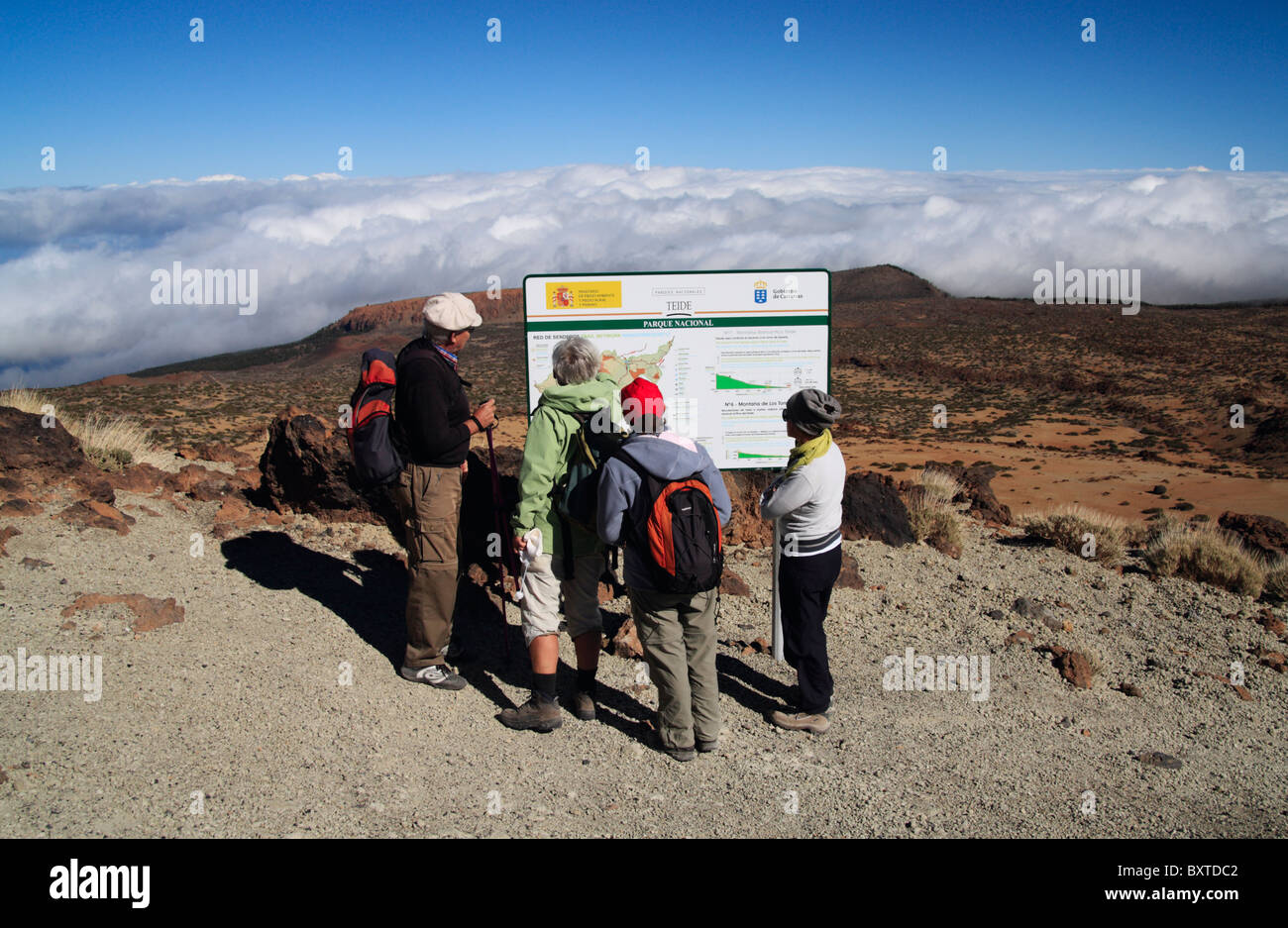 Group of walkers reading imformation board on footpath to the summit of El Teide on Tenerife in the Canary Islands Stock Photo
