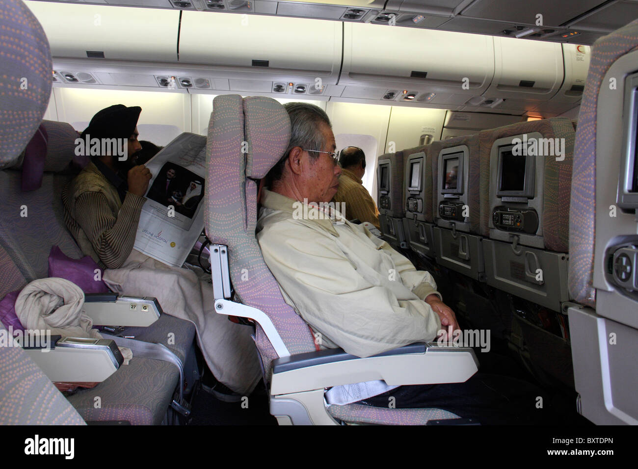 multi ethnic passengers in a flight watching movies and television Stock Photo