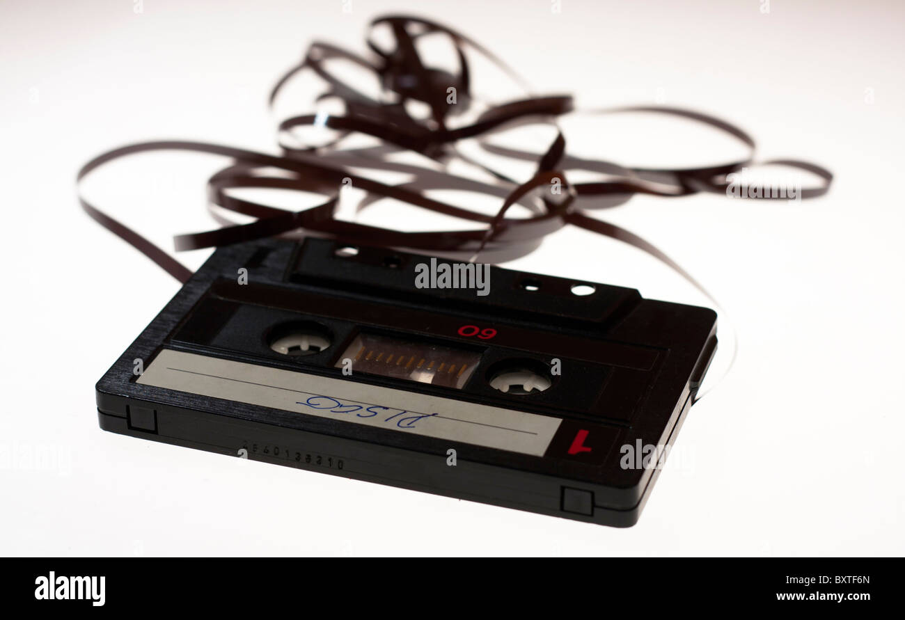 Classic audio cassette with tape out of the case isolated on white. Stock Photo