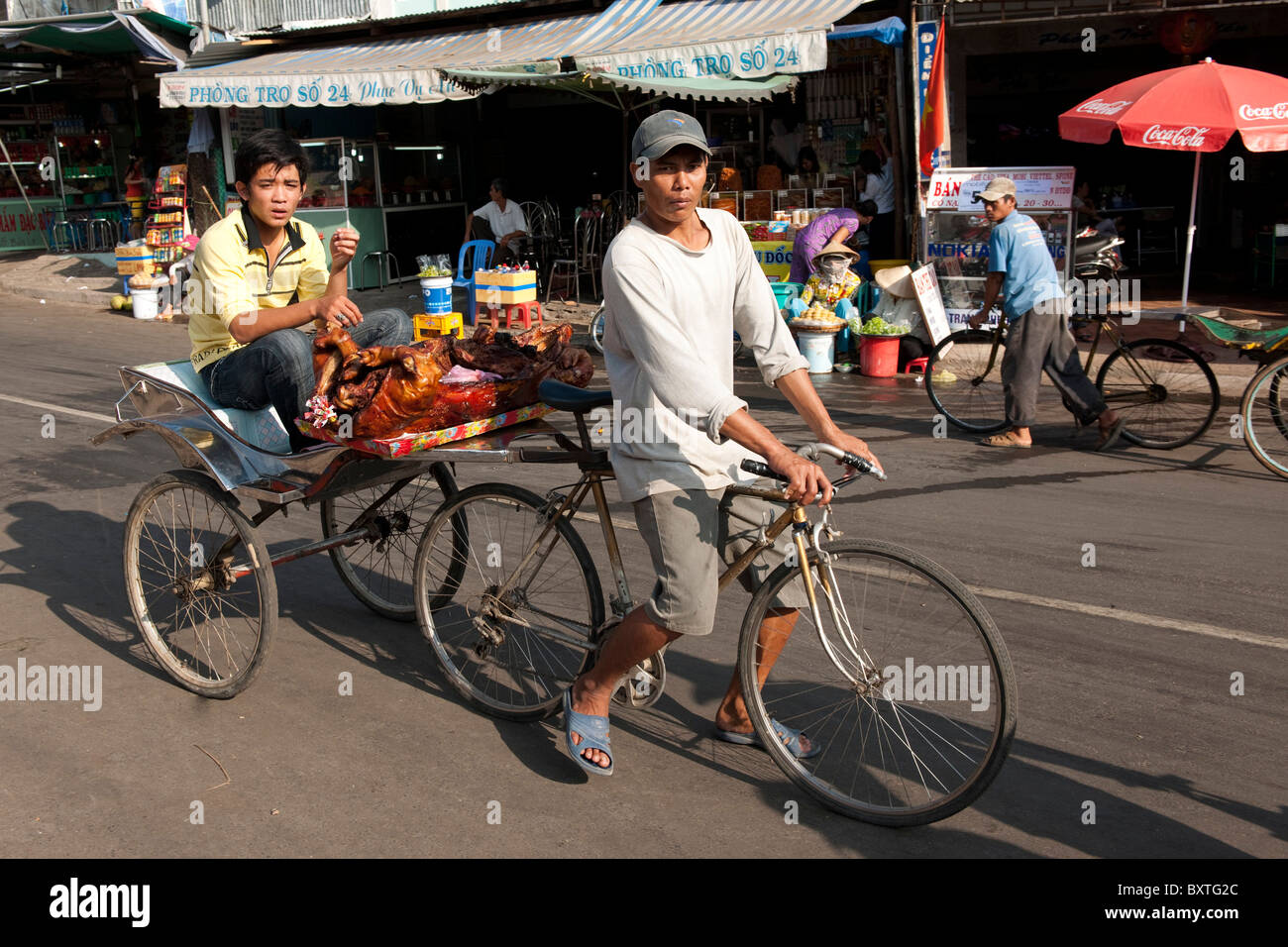 Man transporting roast pig for Tet festivities, Mekong Delta, Chau Doc, Vietnam Stock Photo