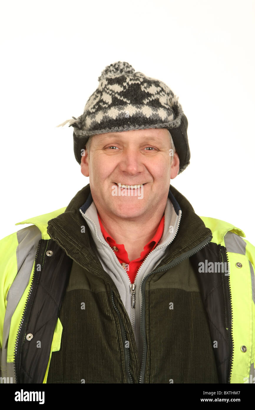 Workman wearing heavy winter clothing and knitted hat Stock Photo