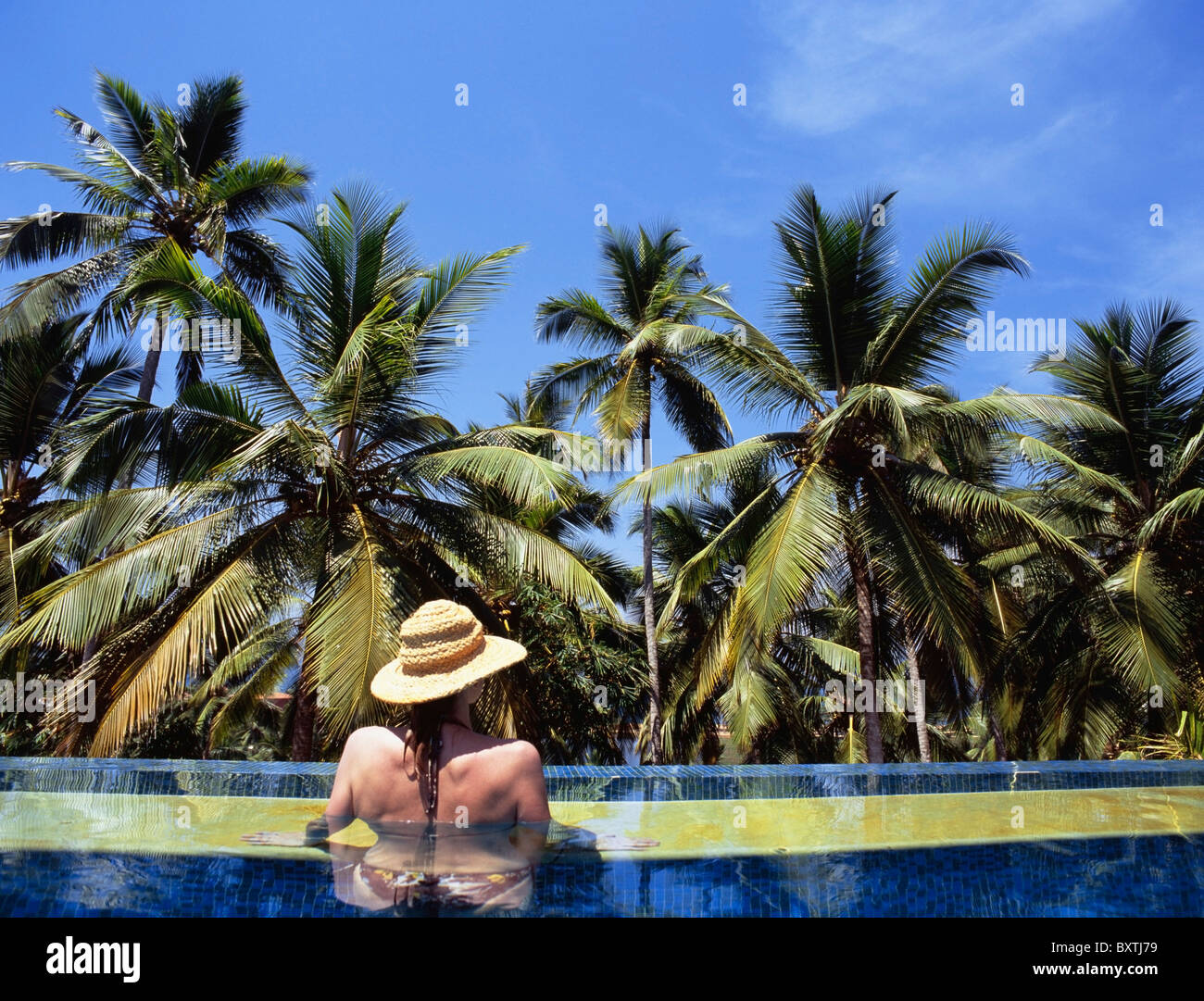 Woman With Straw Hat Relaxing In Swimming Pool Stock Photo - Alamy
