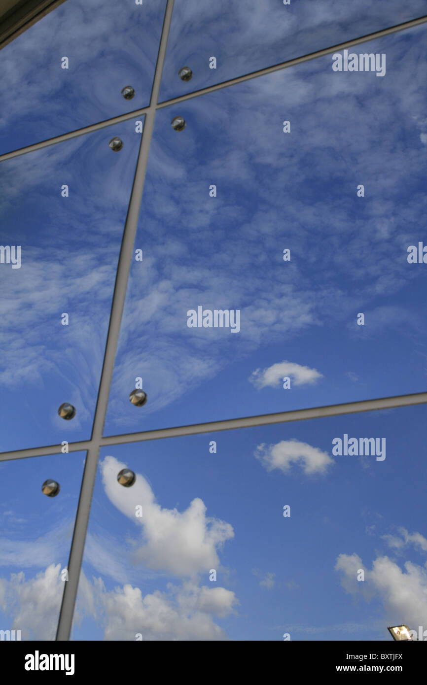 clouds reflection in a row of glass mirror panes Stock Photo