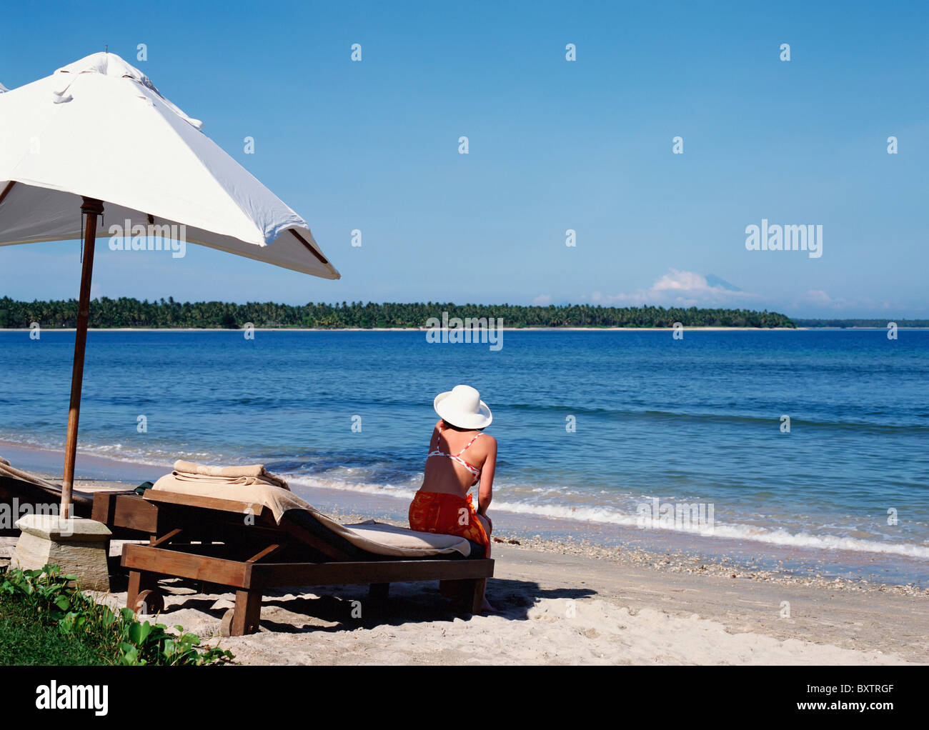Woman Sitting Alone On Beach Stock Photo - Alamy