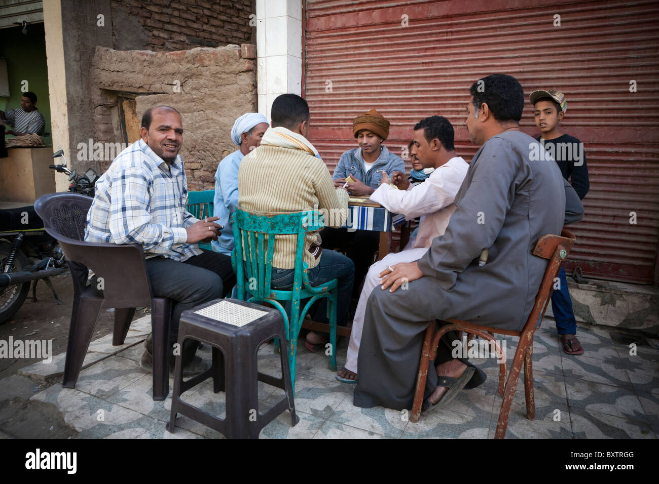 Men sitting playing dominoes outside a cafe at a local street market, Luxor, Egypt, Africa Stock Photo