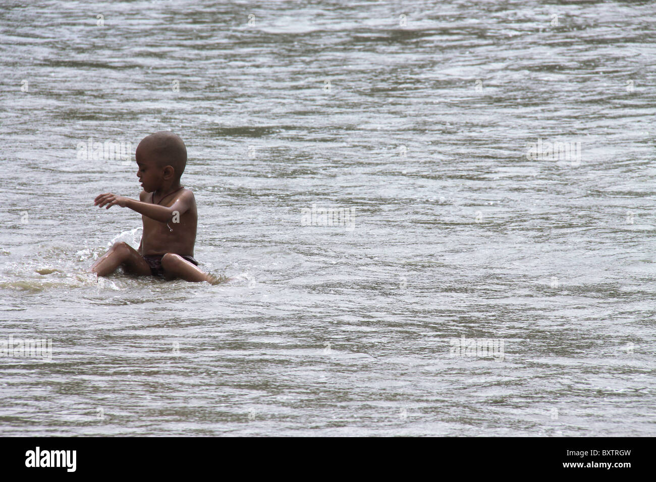 Boy on beach playing in water Stock Photo