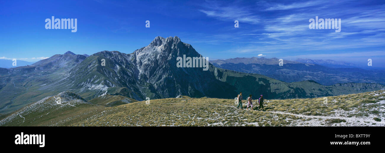 Hikers Going Up Ridge With Corno Grande Behind, Campo Imperatore Stock Photo