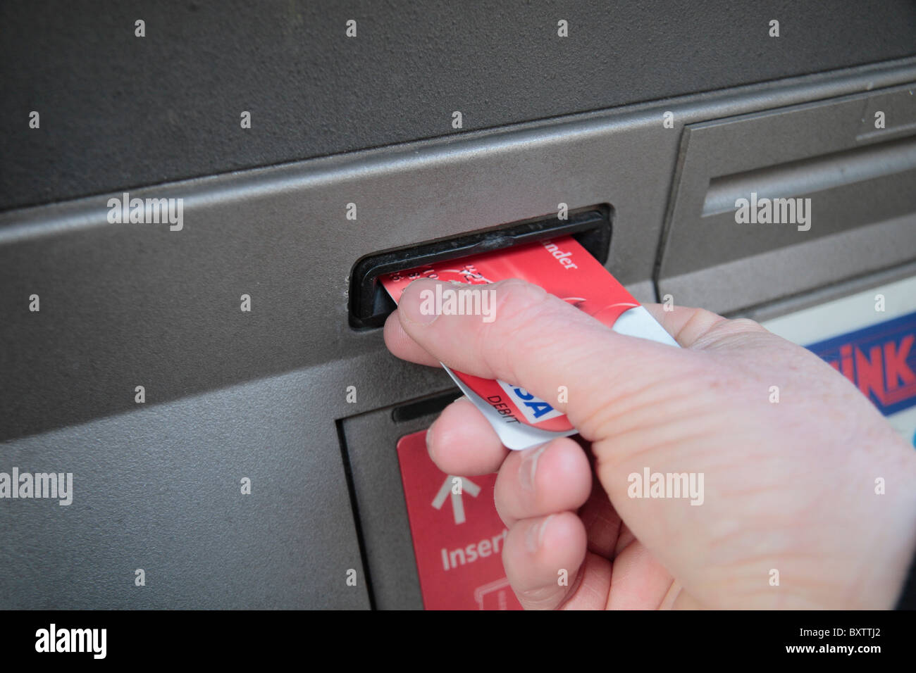 Close up of a man putting his VISA card into a cash machine. Stock Photo