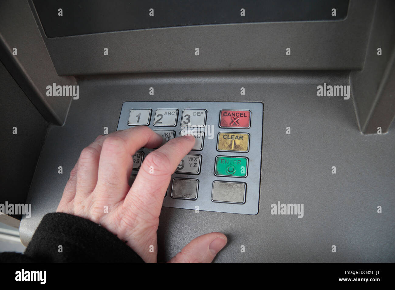 Close up of man inputting pin number into cash machine keypad. Stock Photo