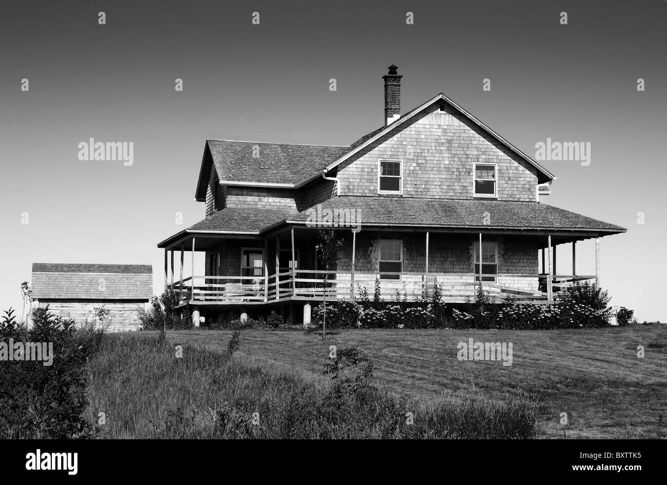 Scary old looking cedar wood shingle farm house on top of a hill. Stock Photo
