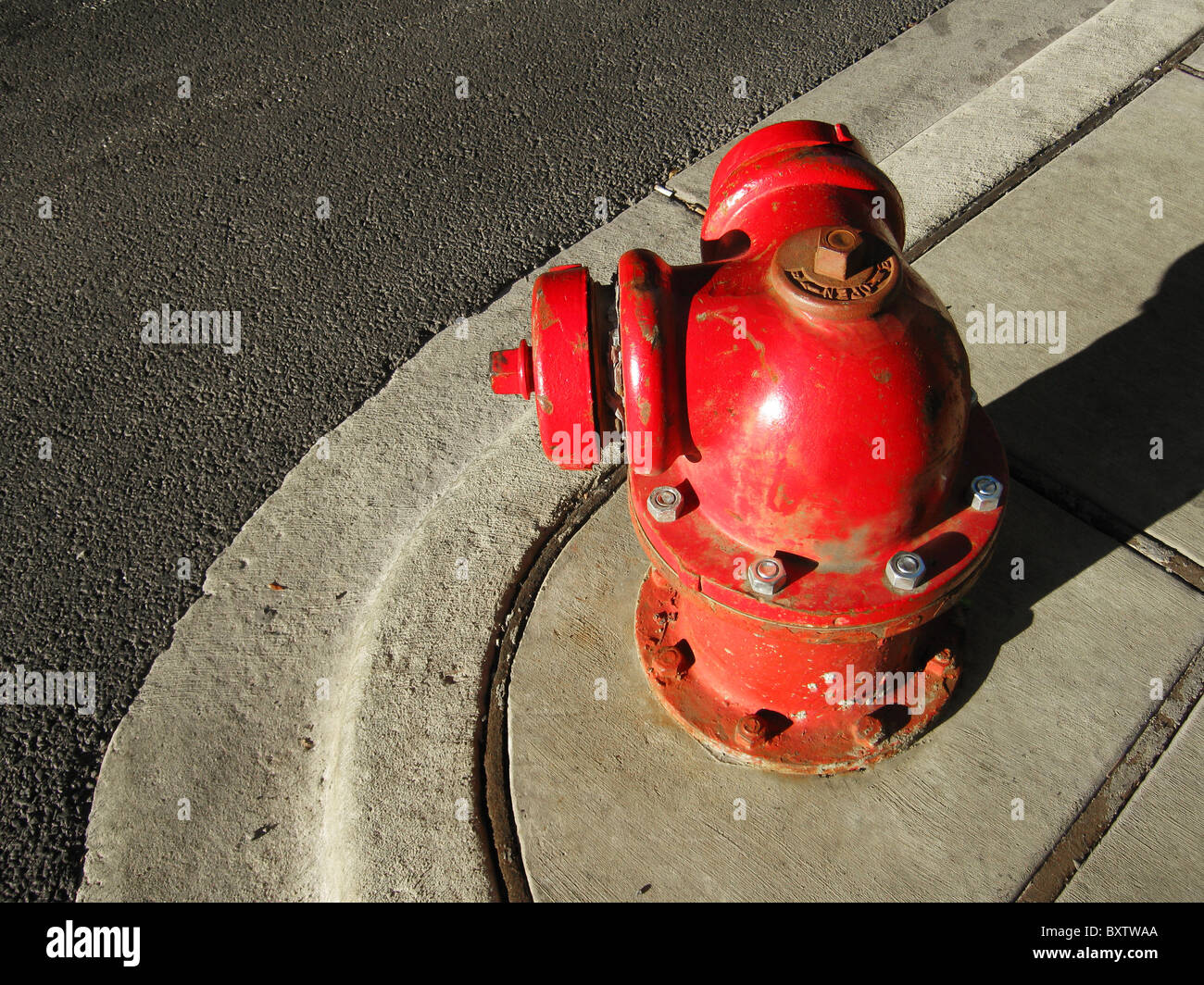 Old style round red fire hydrant on the corner of a street in the city. Stock Photo