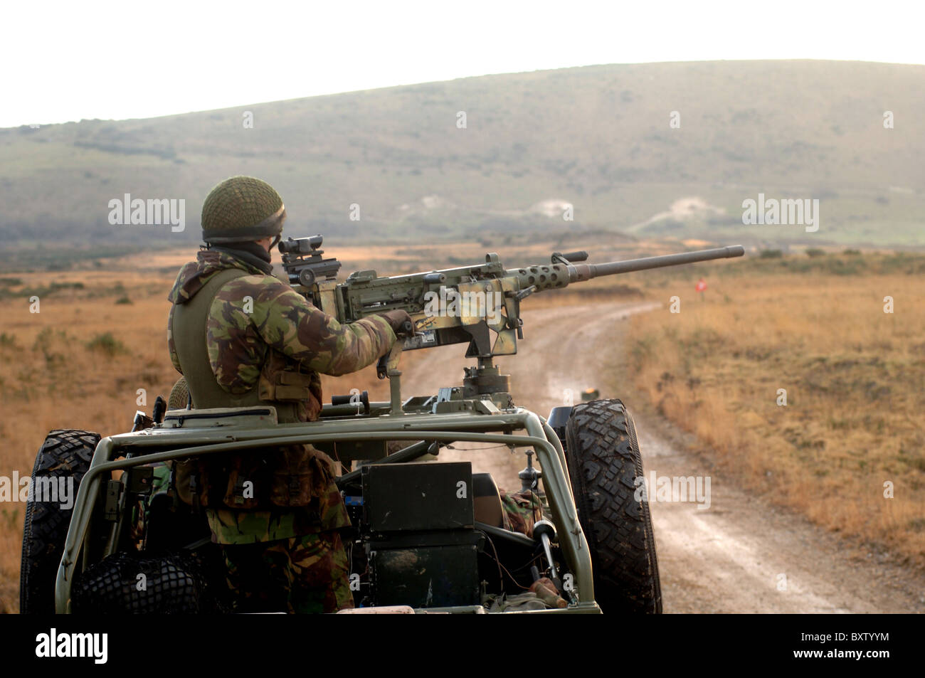 A member of the Pathfinder Platoon fires a heavy machine gun atop a Land Rover. Stock Photo