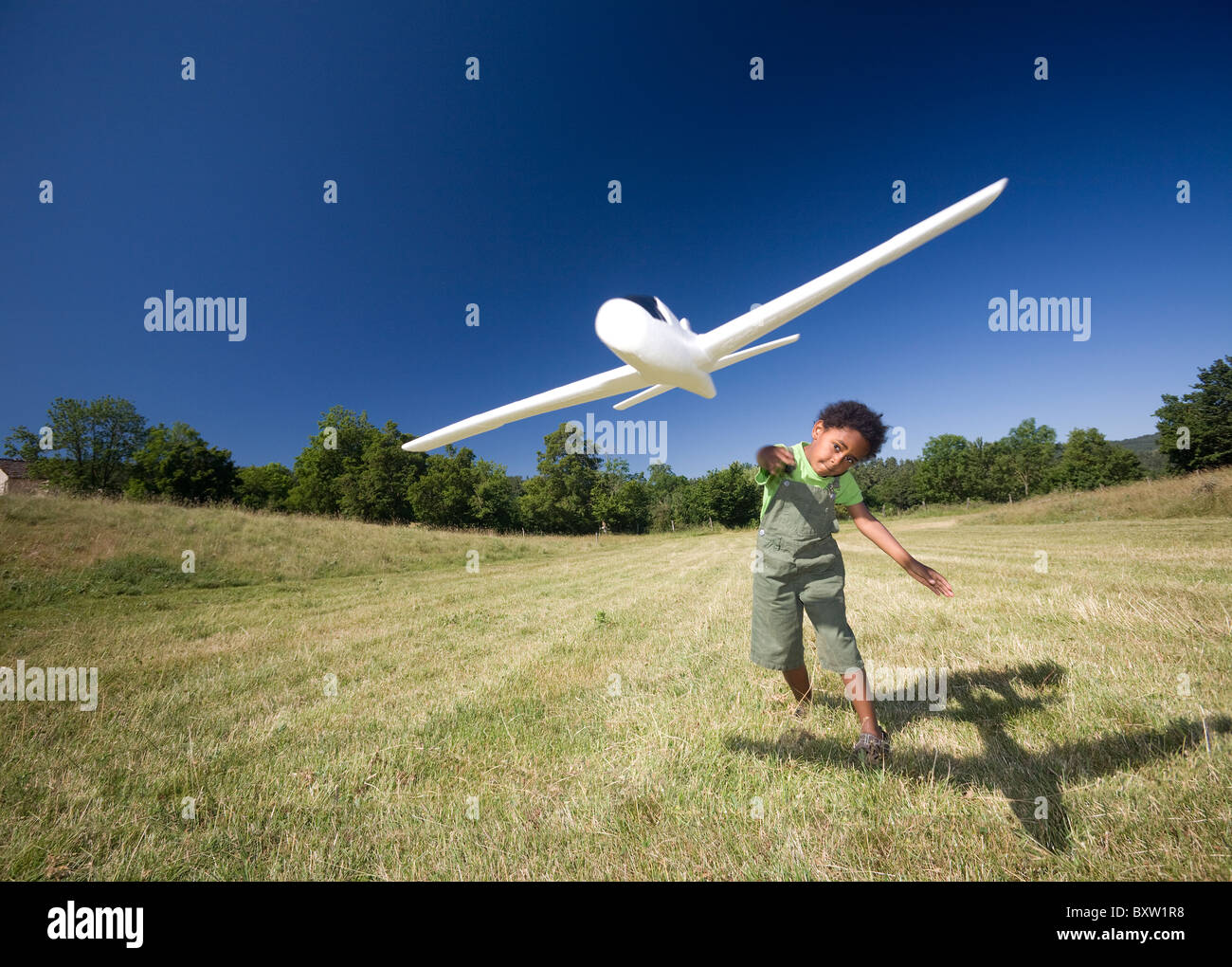 A little black boy playing with a scale model of a plane (Allier - France). Petit garçon jouant avec un modèle réduit d'avion. Stock Photo