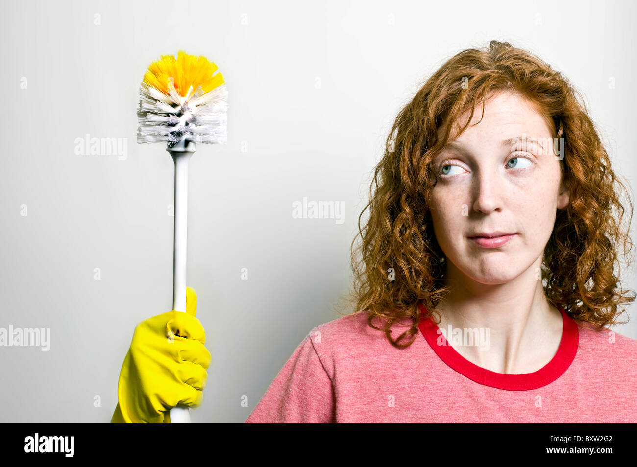 A redheaded woman holding a toilet brush Stock Photo Alamy