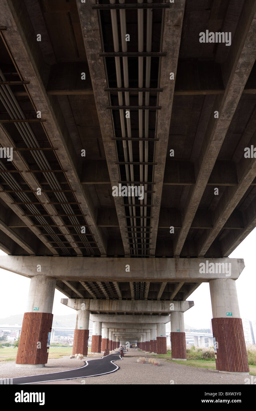 Cycling infrastructure, bike path underneath Chenglu Bridge, near Tamsui River, Wugu District, Taipei, Taiwan Stock Photo