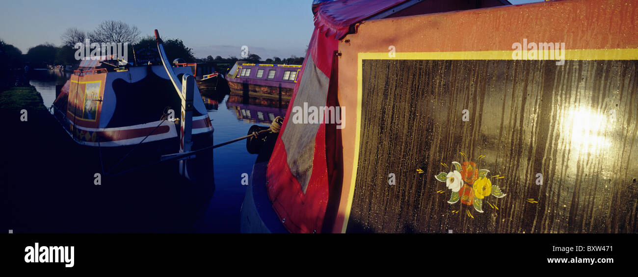 Multi colored barges moored at canal, dusk Stock Photo