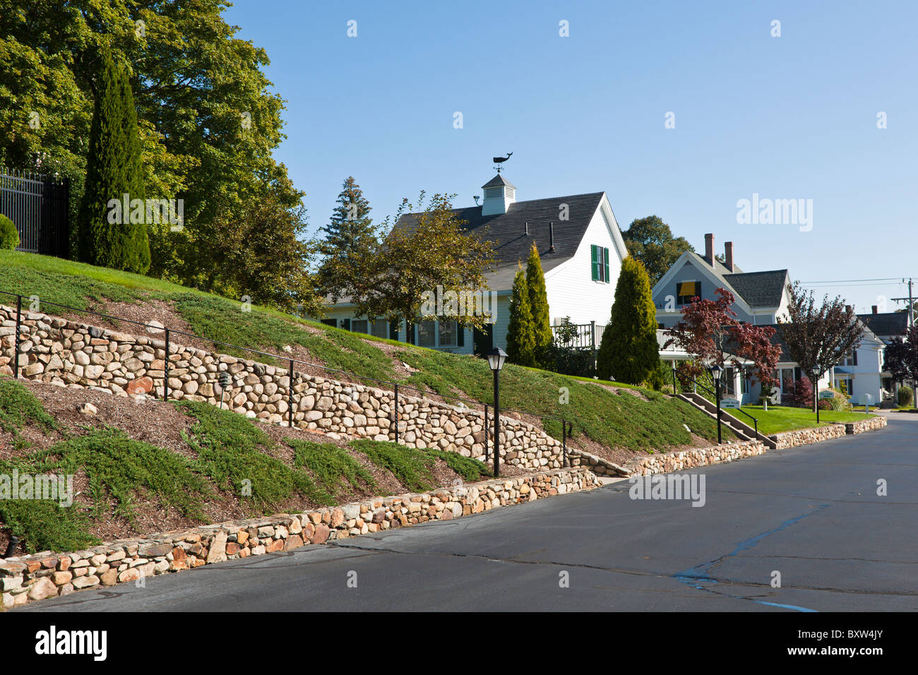 Whale shaped weather vane on roof of house behind stone lined walkway in Plymouth Massachusetts Stock Photo
