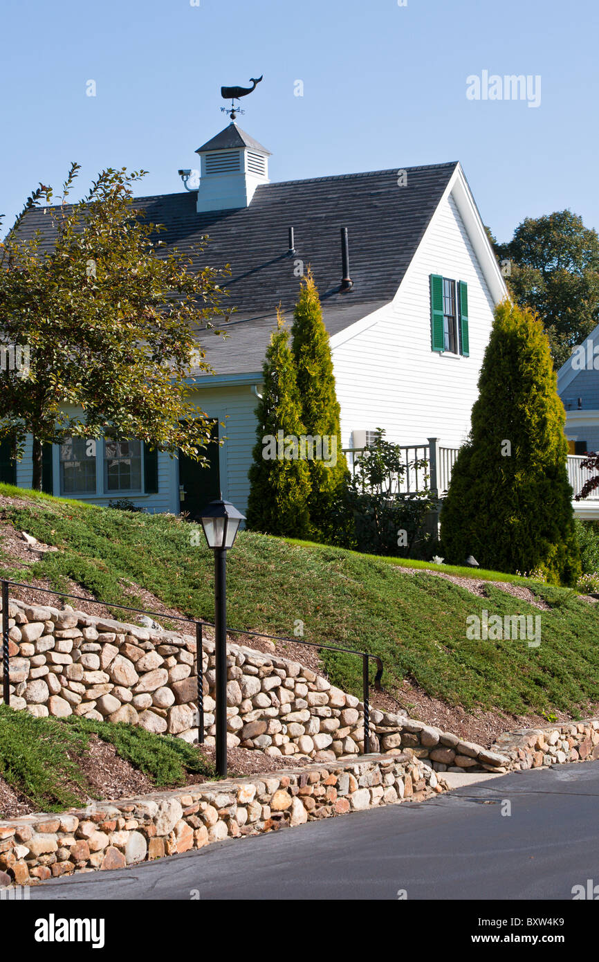 Whale shaped weather vane in roof of house behind stone lined walkway in Plymouth Massachusetts Stock Photo