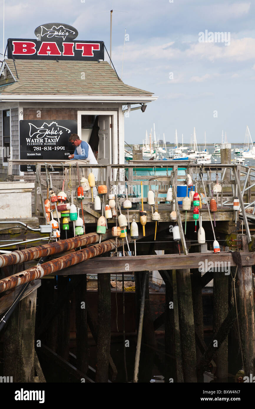 Lobster buoys hang on railing in front of Jake's Water Taxi and Bait shop on the Town Wharf in Plymouth Massachusetts Stock Photo