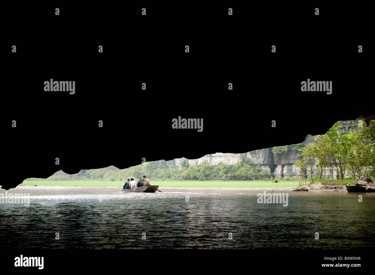 Boats passing a long cave passage on the river, Tam Coc, Ninh Binh, Vietnam Stock Photo