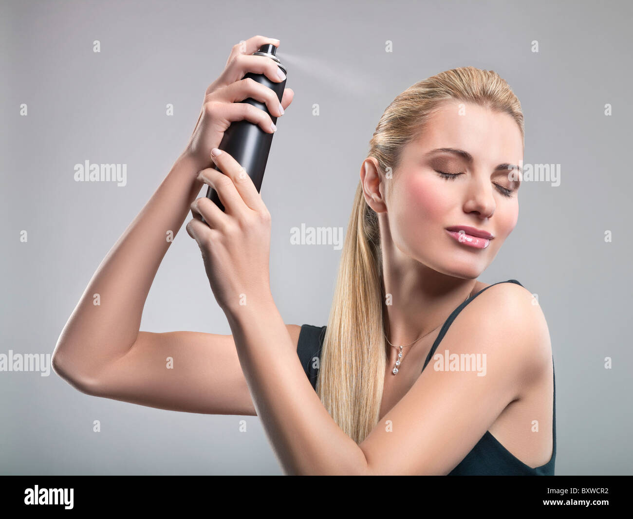 Young woman using hairspray Stock Photo Alamy