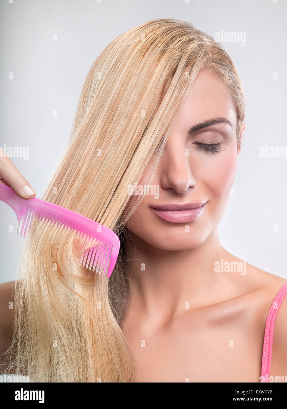 Young woman combing hair Stock Photo Alamy