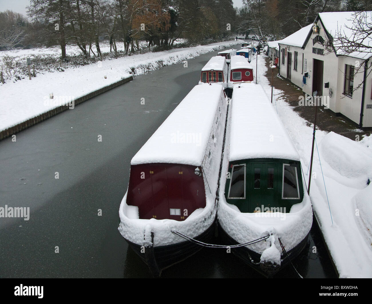 Canal boats in the snow at Farncombe Boathouse on the River Wey in Godalming Surrey Stock Photo