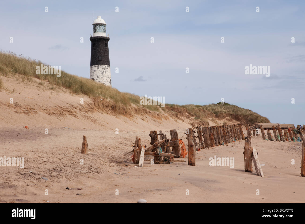 The beach on Spurn Point showing lighthouse and sea defences Stock Photo