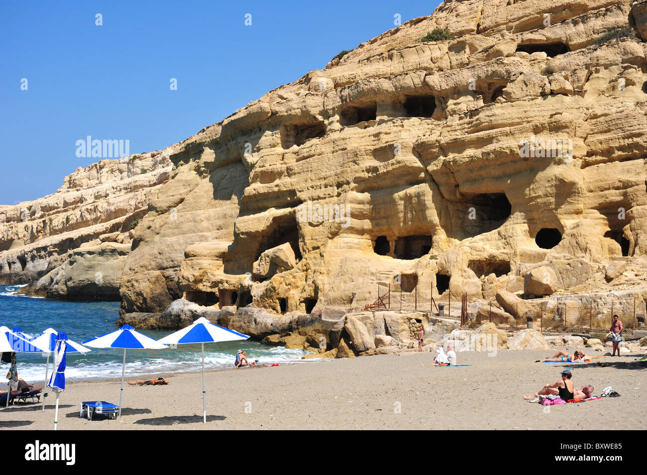 The beach and sandstone cliffs at Matala in Crete. Stock Photo