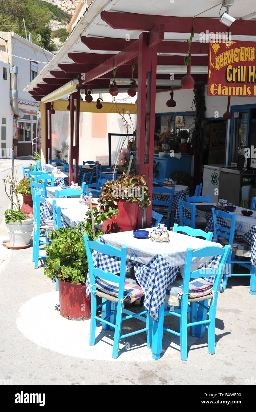 Traditional Greek restaurant with blue tables and chairs in Matala