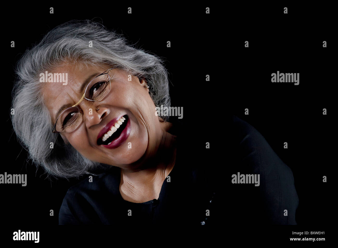 Old woman with glasses laughing Stock Photo