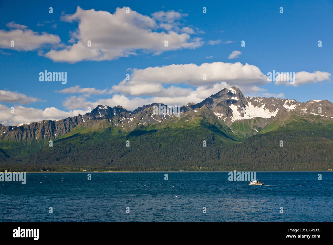 Mountains across Resurrection Bay on the Kenail Peninsula in Seward Alaska with small boat in bay Stock Photo