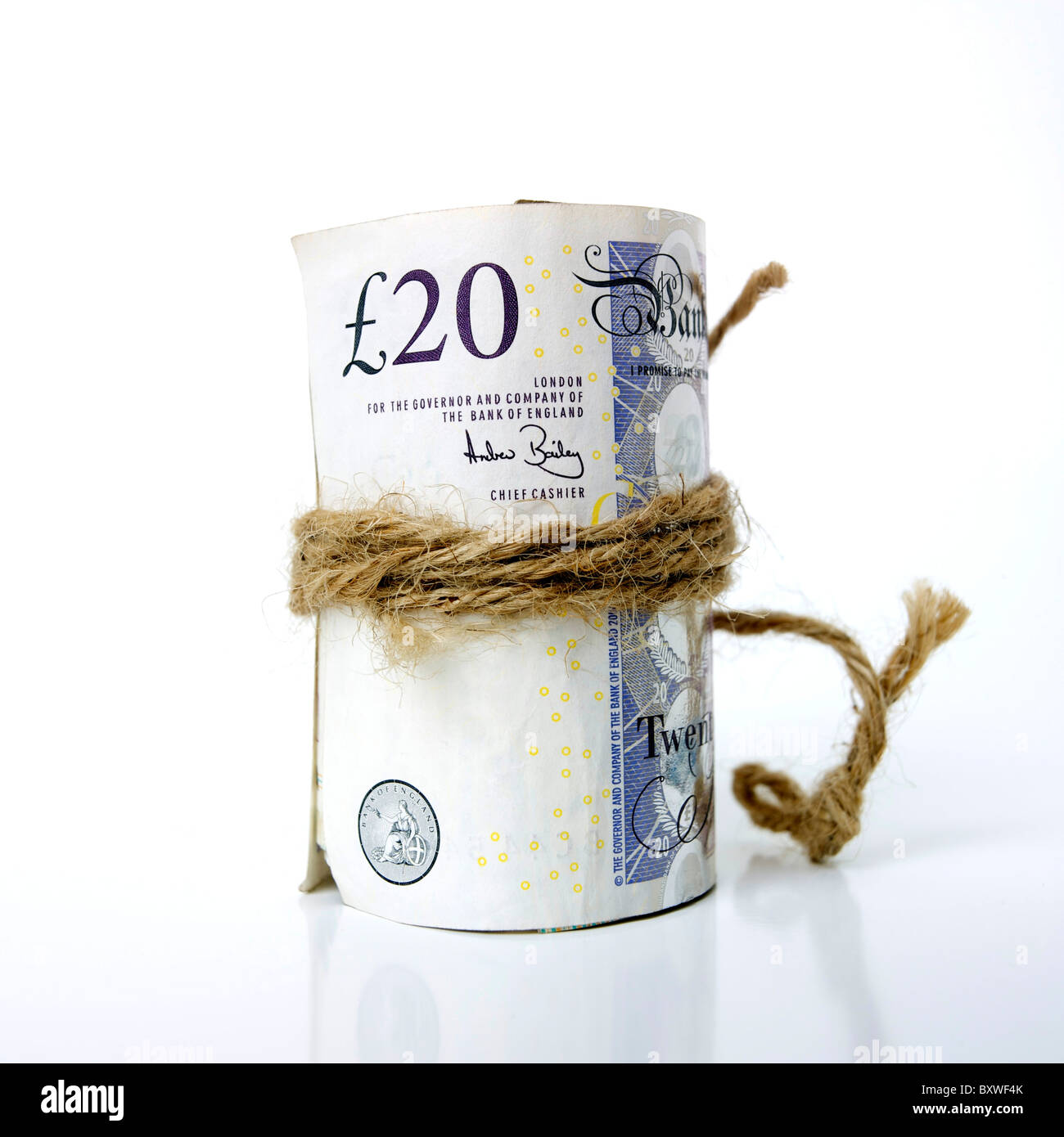 Rolled bunch of pound sterling UK British banknotes tied up and secured with string / rope Stock Photo