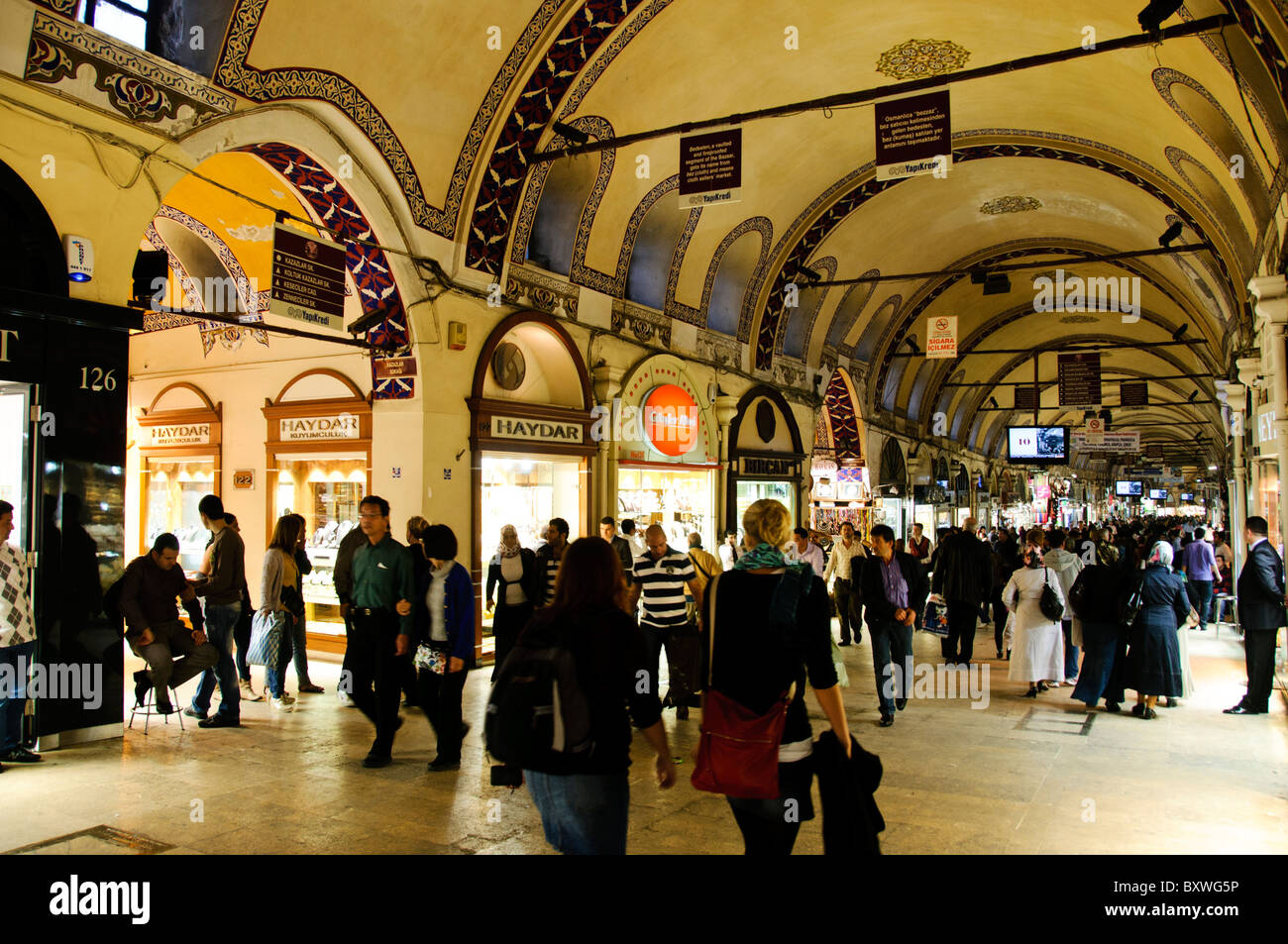 ISTANBUL, Turkey — A busy street on the main strip of Istanbul's historic Grand Bazaar. The bazaar's streets are all covered, with the ceilings often ornately painted. The Grand Bazaar, one of the largest and oldest covered markets in the world, is a bustling hub of commerce and culture in Istanbul. Featuring a maze of over 4,000 shops, it offers a vibrant array of goods, from spices and jewelry to textiles and ceramics. The Grand Bazaar's historic architecture and lively atmosphere attract millions of visitors each year. Stock Photo