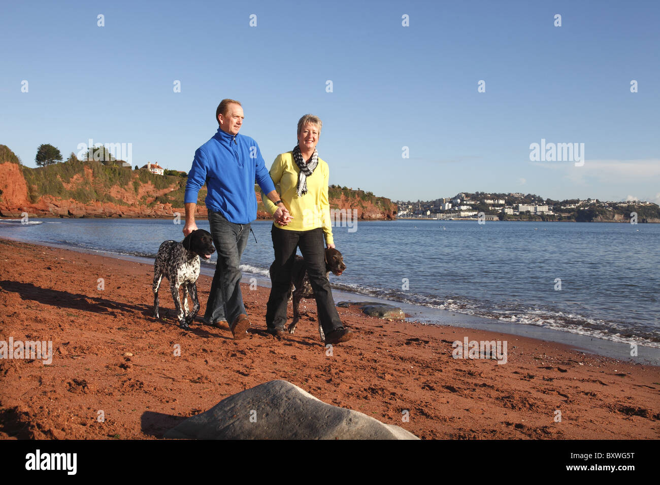 A couple walking on the beach between Torquay and Paignton. Stock Photo