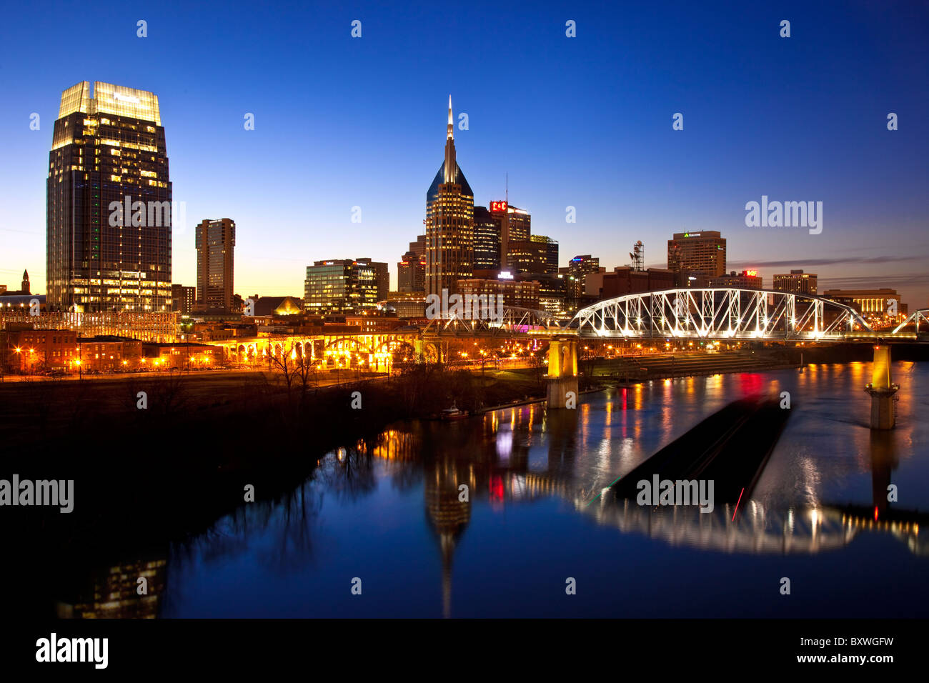Coal Barge transiting the Cumberland River at twilight through Nashville Tennessee, USA Stock Photo
