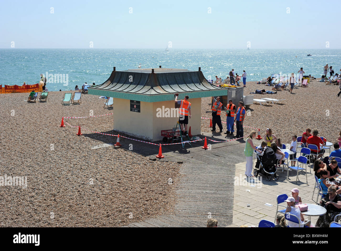 Young offenders painting a small hut on Brighton beach as part of the community Payback scheme Stock Photo