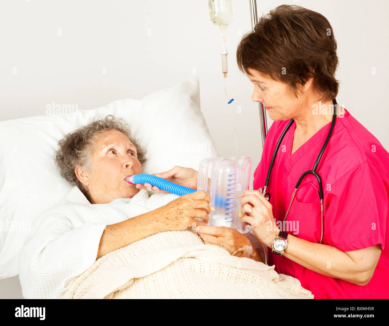Nurse helps senior patient do breathing exercises in the hospital Stock