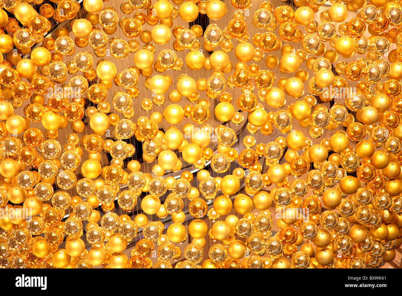 Christmas decoration in a shopping mall.  Many golden Christmas tree balls forms a giant ball. Stock Photo