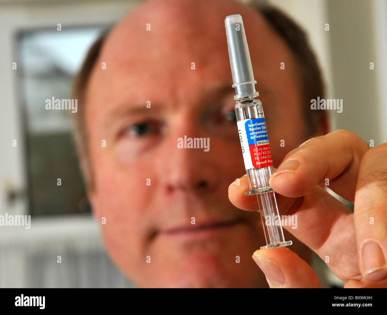 Flu vaccine, GP holding a flu vaccine syringe, UK Stock Photo