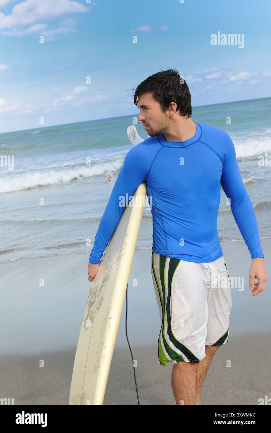 Man with surfboard on a florida beach. Stock Photo