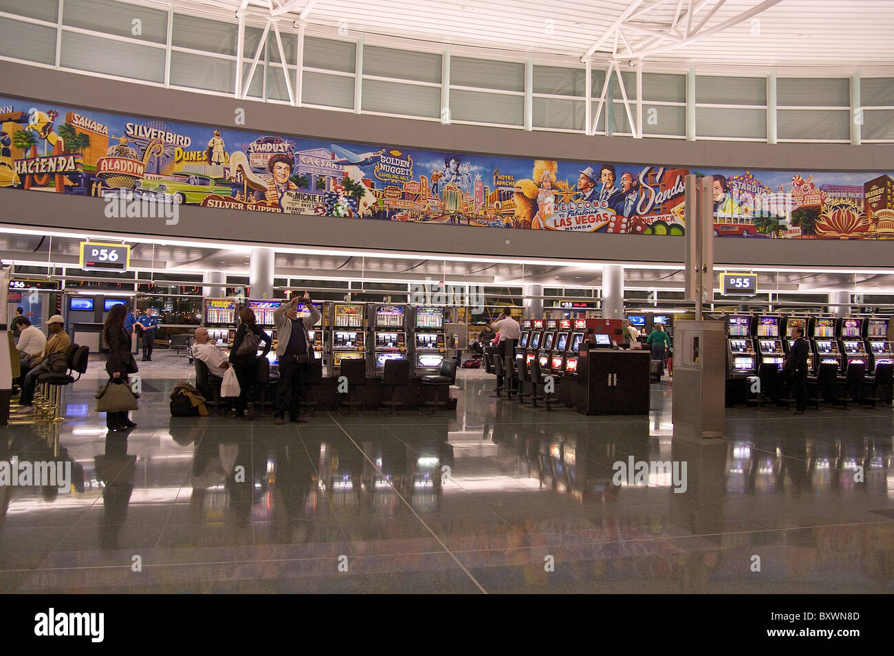 Slot machines and a mural depicting famous Las Vegas landmarks and celebrities at McCarran International Airport Stock Photo