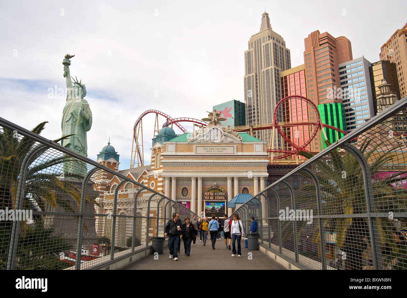 People walk on a pedestrian bridge near the New York New York Las Vegas Hotel and Casino Stock Photo