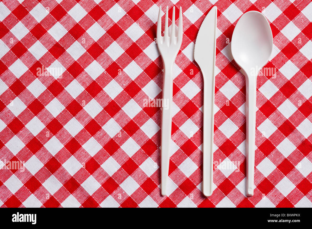 the plastic cutlery on checkered tablecloth Stock Photo