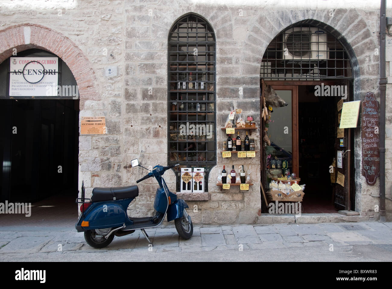 Scooter parked outside a typical Umbrian produce shop in Gubbio, Italy Stock Photo