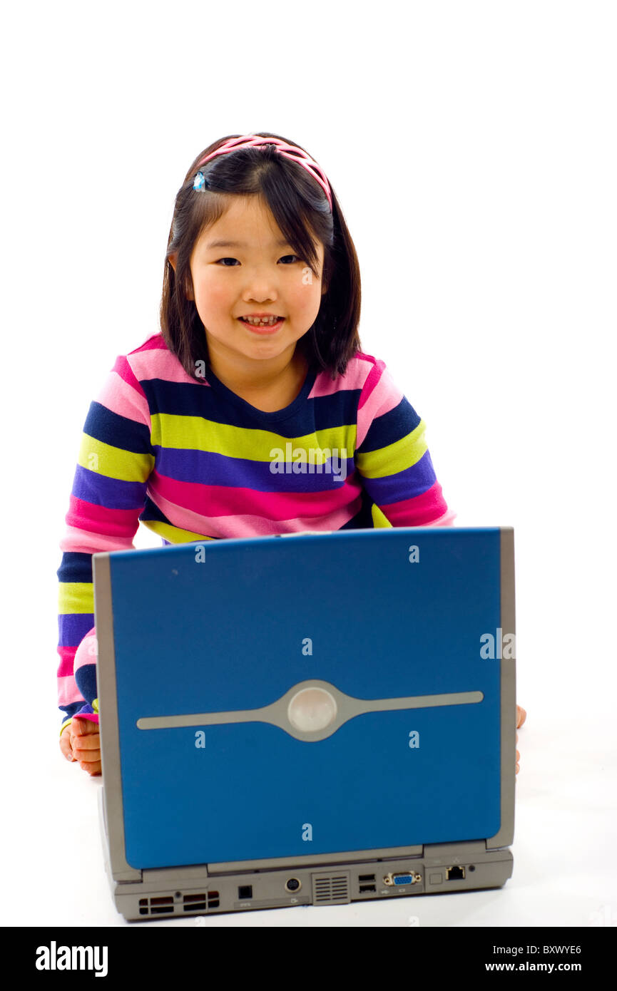 Adorable little Asian girl working on laptop , isolated over white ...
