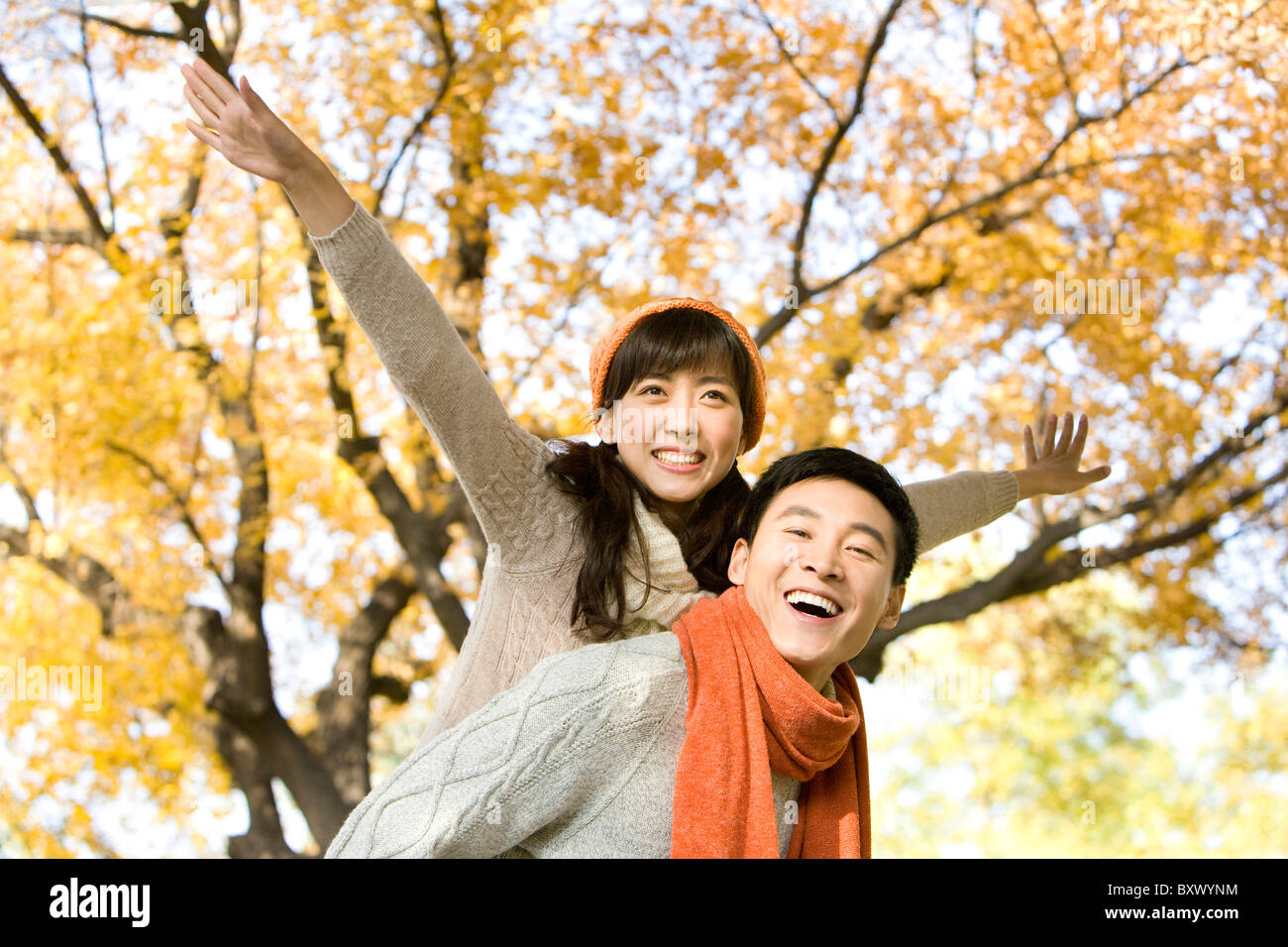 Young Couple Playing in a Park in Autumn Stock Photo - Alamy